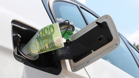 Ein Geldschein in einer Auto-Tankklappe. © fotolia.com Foto:  babimu