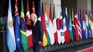 US-Präsident Joe Biden geht während des G20-Gipfels in Indonesien an den Flaggen der Teilnehmerländer vorbei. © dpa Foto: Mast Irham