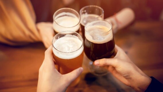 Vier Hände halten vier Biergläser und stoßen damit an. © Colourbox Foto: Sonjachnyj