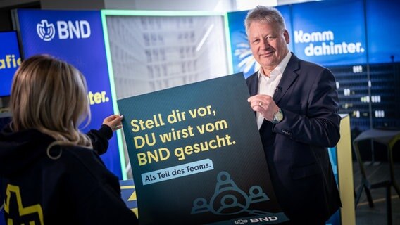 Bruno Kahl, Präsident des Bundesnachrichtendienstes, zeigt ein Plakat mit dem Schriftzug "Stell dir vor, Du wirst vom BND gesucht". © dpa Bildfunk Foto: Michael Kappeler