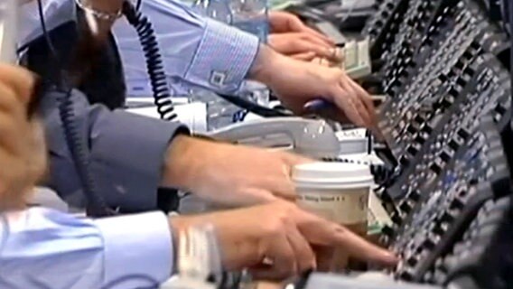 Viele Hände von Mitarbeitern in einer Börse, die zum Telefon greifen © NDR 
