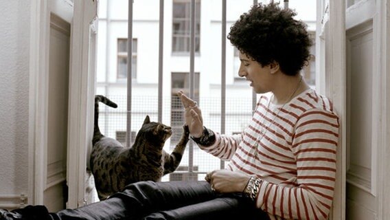 Popsänger Andreas Bourani spielt mit einer Katze. © Universal Music 