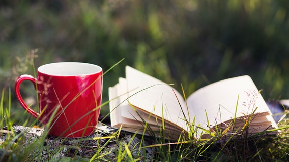 Eine Tasse und ein aufgeschlagenes Buch © photocase.de Foto: Rike