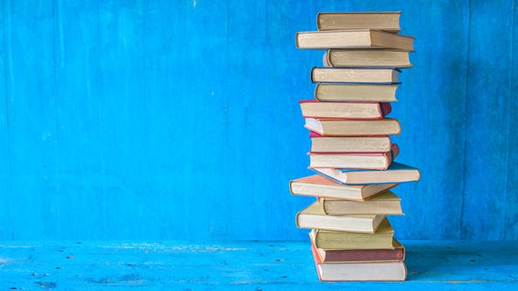 Ein Stapel Bücher vor blauem Hintergrund © picture alliance / Shotshop Foto: luftquallenpapst
