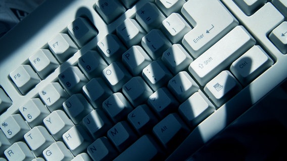 Der Schatten einer Hand liegt über einer Tastatur. © fotolia.com Foto:  Feng Yu