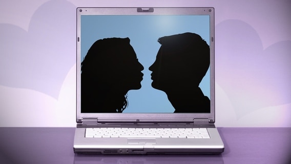 Auf einem Laptopmonitor küsst sich ein Paar, das nur als Schattenriss zu sehen ist. © fotolia Foto: kaipity, sashpictures