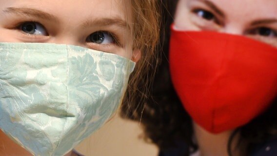 Eine Frau und ein Mädchen tragen selbstgenähte Schutzmasken. © picture alliance Foto: Waltraud Grubitzsch