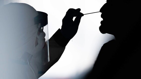 Ein Mann wird per Stäbchen in einem Testzentrum auf das Coronavirus getestet. © Lino Mirgeler/dpa 