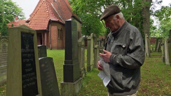Ein älterer Herr steht auf dem jüdischen Friedhof in Lübeck © NDR 