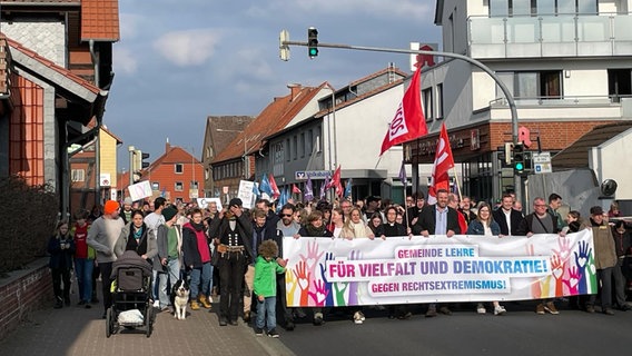 Menschen in einem Protestzug mit Fahren und Banner. © Ev.-luth. Kirchengemeinde Lehre-Brunsrode 