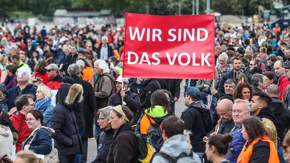 Demonstranten halten ein Transparent mit der Aufschrift "Wir sind das Volk". © dpa Foto: Christoph Schmidt