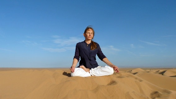 Yogalehrerin Barbara Kleymann im Lotussitz in der Wüste © Barbara Kleymann 