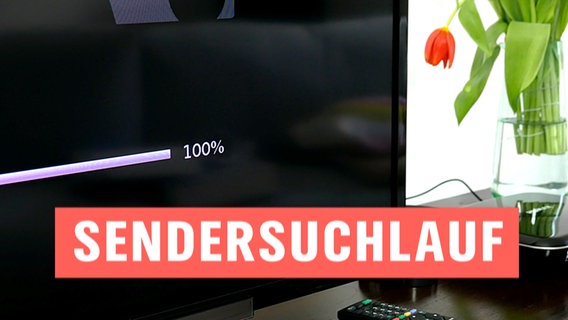 Tisch mit einem Fernseher, der den Sendersuchlauf zeigt.  