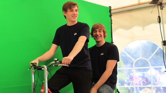 Zwei junge Leute auf dem Fahrrad vor der Green Screen. © NDR 