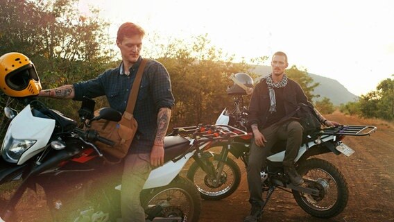 Patrick Weinert und Dennis Weinert machen während ihrer Reise entlang des Mekong eine kurze Pause auf den Motorrädern. © NDR 
