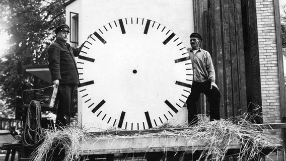 Zwei Männer mit dem großen Ziffernblatt am Uhrenturm  