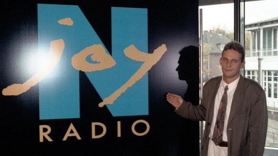Torsten Engel vor dem Logo von N-JOY als Projektleiter Jugendradio (1994) © NDR Foto: Michael Lotz