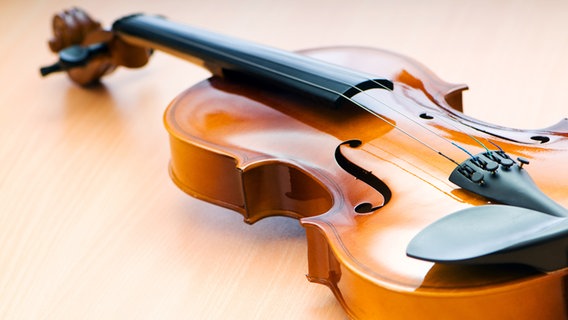 Eine Geige liegt auf einem Holzuntergrund © Colourbox Foto: -