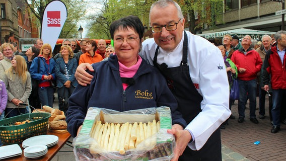 Rainer Sass, Annelie Blesse, Spargelhändlerin auf dem Nienburger Wochenmarkt. © dmfilm und tv produktion GmbH & Co. KG 