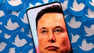 Elon Musk, der Gründer von SpaceX und Tesla, im Porträt auf einem Handy, im Hintergrund viele Twitter-Symbole © Reuters Foto: DADO RUVIC