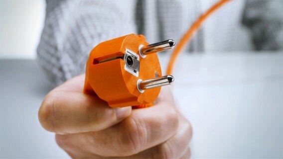 Hand hält den Stecker eines Elektrogerätes. © fotolia.com Foto: Eisenhans