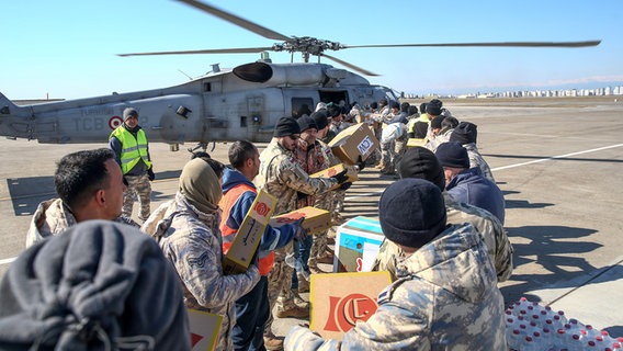 Menschen tragen Hilfspakete in einen Helikopter. © picture alliance / AA | Ozan Efeoglu Foto: Ozan Efeoglu