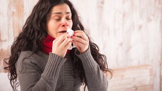Erkältete Frau niest in ein Taschentuch. © fotolia Foto: Viacheslav Iakobchuk