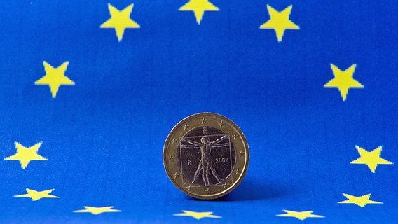 Eine 1-Euro-Münze, im Hintergrund die europäische Fahne. Eine 1-Euro-Münze, im Hintergrund die europäische Fahne. © dpa picture alliance Foto: CHROMORANGE / Monika Wirth