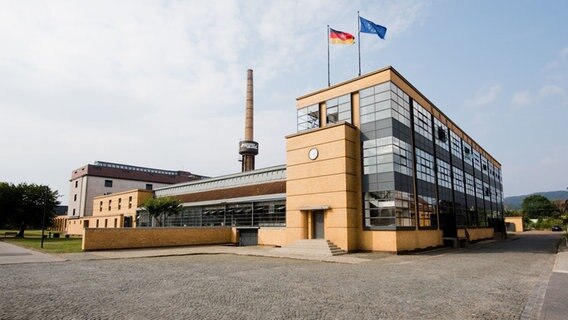 Eine Deutschland- und eine Europaflagge wehen auf einem Industriegebäude. © dpa-Bildfunk Foto: Julian Stratenschulte