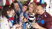 Junge Erwachsene feiern fröhlich mit Sekt und Konfetti Silvester. © fotolia Foto:  gpointstudio