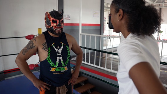 Luchador Alan spricht mit Sara Nuru im Kampfring. © NDR/doclights/Tina Muffert 