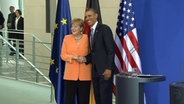 Bundeskanzlerin Angela Merkel und der US-amerikanische Präsident Obama geben sich die Hand.  