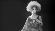 Die dänische Schauspielerin Asta Nielsen in der Rolle als "Mizzi" im Stummfilm "Die freudlose Gasse" (1925). Sie trägt ein aufwendiges Kleid und einen prachtvollen Kopfschmuck mit einer Art Afro-Frisur. © picture alliance 