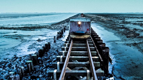 Hanni, der Postbote, fährt auf seiner Lore durch das Wattenmeer. © NDR/Pieter-Rim de Kroon 