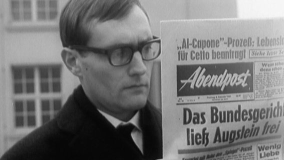 Rudolf Augstein liest in einer Zeitung mit der Titelstory "Das Bundesgericht ließ Augstein frei".  