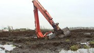 Ein Bagger halb versunken  im Moor.  