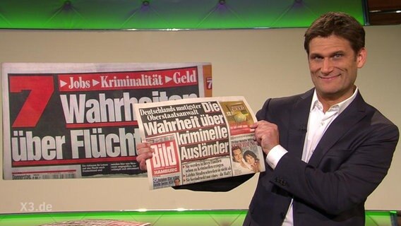Christian Ehring mit einer Bildzeitung in der Hand.  