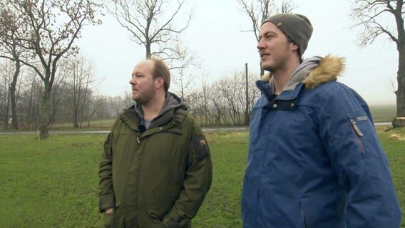 Jasper und Thilo Metzger-Petersen stehen auf einem Feld  