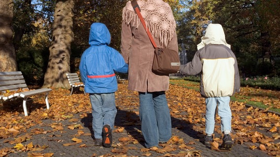 Eine Mutter und zwei Kinder beim Herbstspaziergang. © picture alliance / Caro | Sorge 