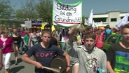 Schüler demonstrieren und halten ein Transparent mit der Aufschrift "Bildung ist ein Grundrecht".  