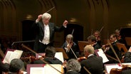 Christoph von Dohnányi dirigiert mit erhobenen Armen das NDR Sinfonieorchester in der Laeiszhalle  