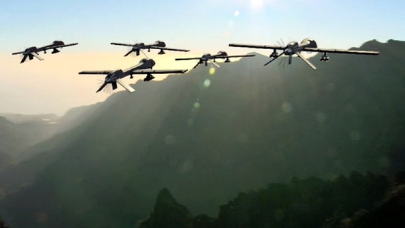 Ein Schwarm Drohnen fliegt auf einen Berg zu.  