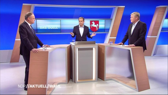 Stephan Weil (SPD) und Bernd Althusmann (CDU) im Studio an gegenüberstehenden Pulten, in der Mitte der Moderator.  