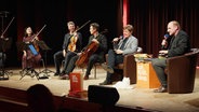 Daniel Kaiser, Jan Ehlert (v.r.) und Musikerinnen und Musiker des NDR Elbphilharmonie Orchesters auf der Bühne © Screenshot 