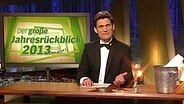 Christian Ehring mit Smoking und Champagnerkübel im Studio.  