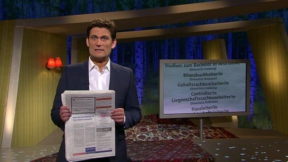 Christian Ehring mit einer Zeitung in der Hand.  
