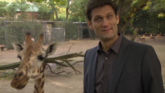 Christian Ehring mit einer Giraffe.  