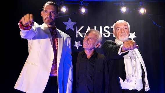 Edwin (Tilo Prückner, M.) traut sowohl Maldini (Dietrich Hollunderbäumer, M.), als auch Kalisto (Felix Rech, l.), den Mord an der Assistentin zu. © © ARD/Kai Schulz, honorarfrei 