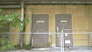 Eine verfallene Fabrik in Ostdeutschland. Zu sehen sind zwei Türen mit der Aufschrift "Personaleingang" und "Küchenabfälle". © NDR 