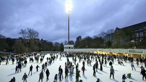 Besucher fahren Schlittschuh auf der EisArena in Planten un Blomen.  